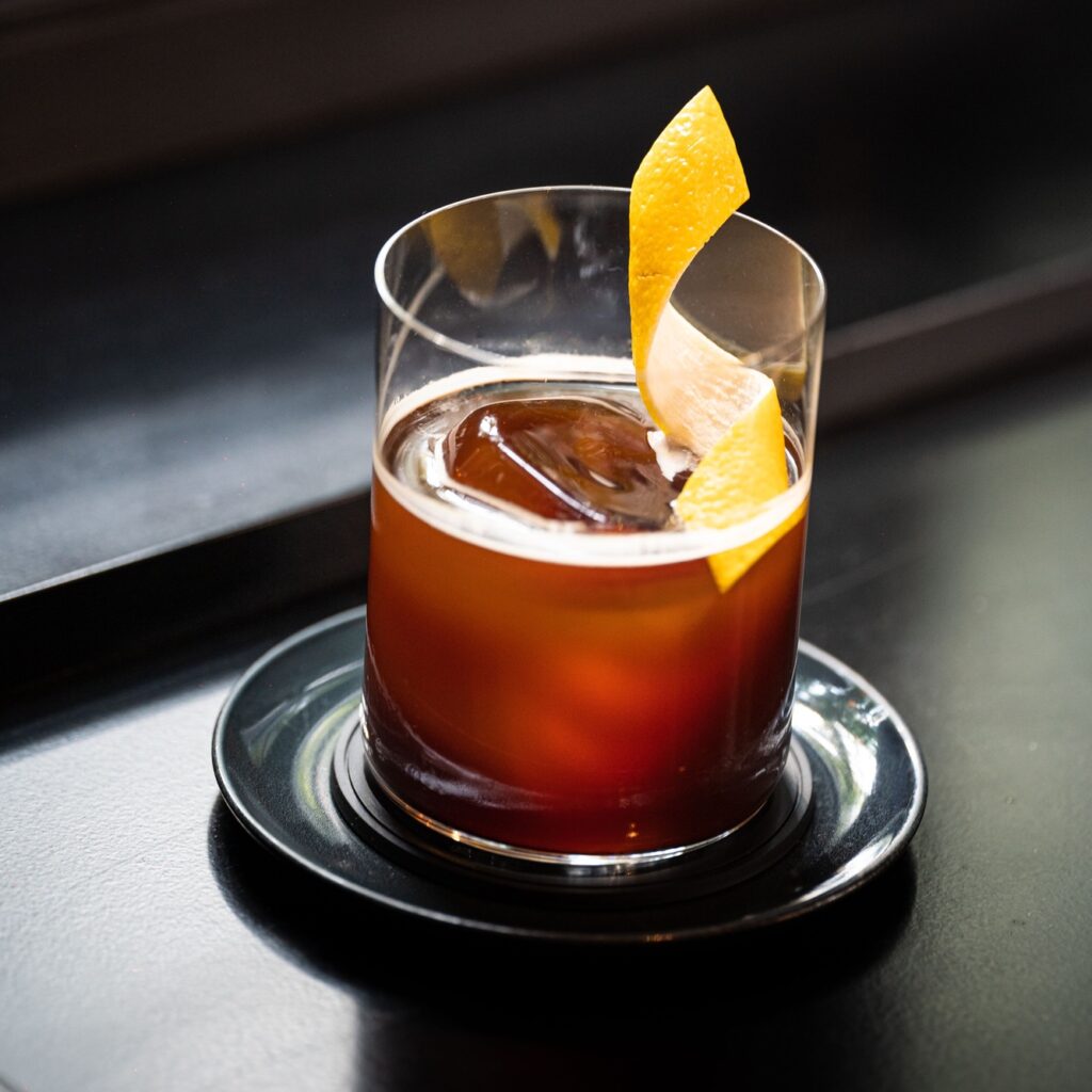Shiny Boulevardier cocktail drink on a black table